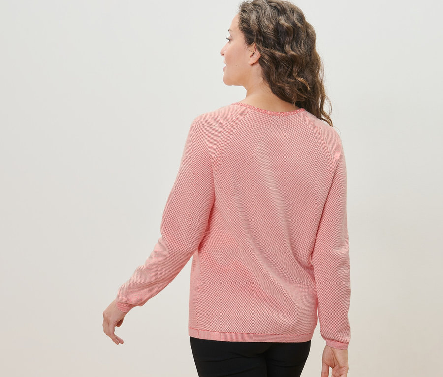 Omzunun üzerinden bakan, örgü kazaklı kadın.