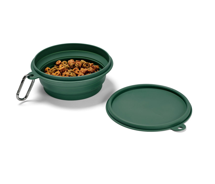Yeşil katlanabilir mama kabı, içinde kuru mama var, yanında da kapağı duruyor.