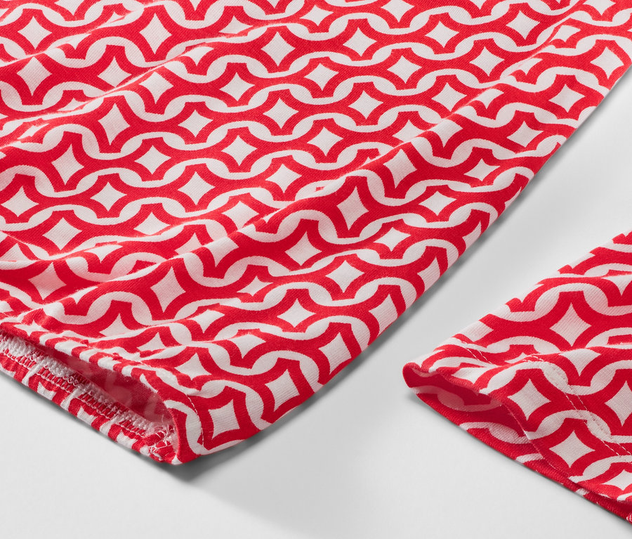 Kırmızı baskılı bluzun yakın çekimi.