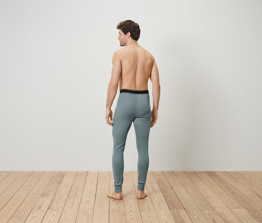 Erkeğin kameraya arkası dönük, gri termal iç çamaşırı giyiyor olmasi