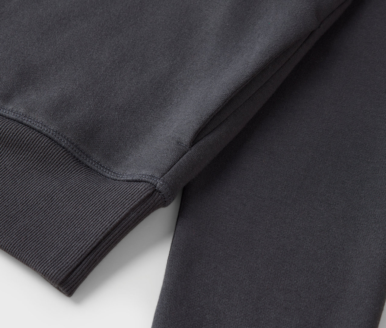 Gri renkte, manşet kısmı fitilli bir sweatshirt'ün yakın çekim görüntüsü.