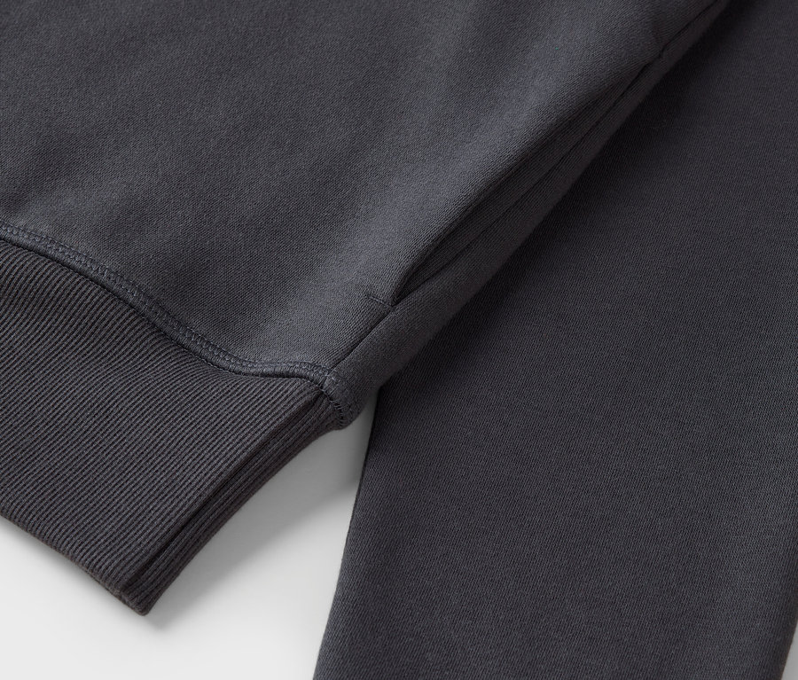 Gri renkte, manşet kısmı fitilli bir sweatshirt'ün yakın çekim görüntüsü.
