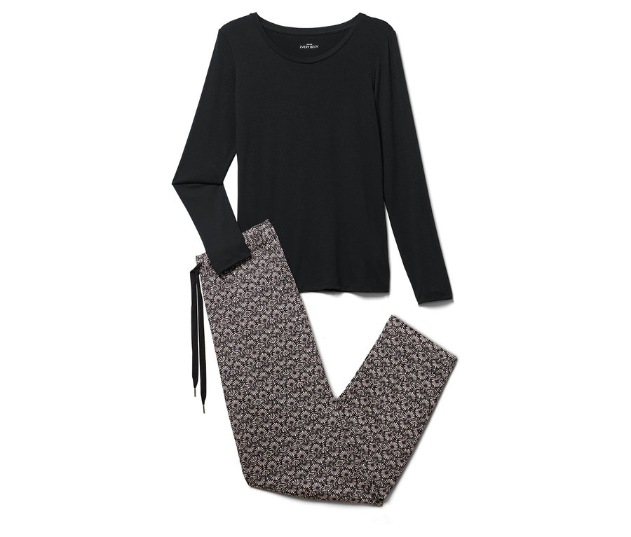 Siyah uzun kollu bir pijama üstü ve çiçekli bir pijama altı beyaz bir zeminde duruyor.