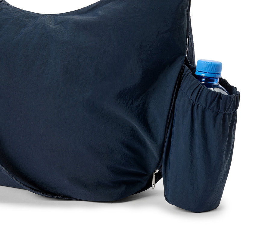 Yan cebinde su şişesi olan koyu mavi bir tote çanta yakın çekimi.