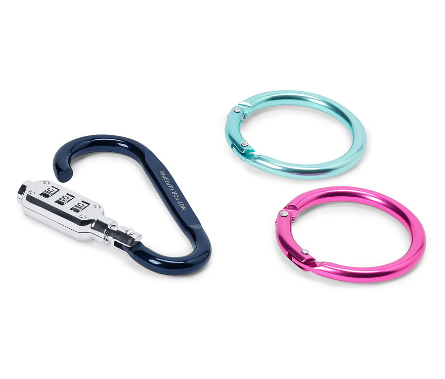 Beyaz bir yüzey üzerinde üç eşya duruyor: siyah ve gümüş renkli şifreli bir karabina ve biri turkuaz, diğeri pembe iki halka.