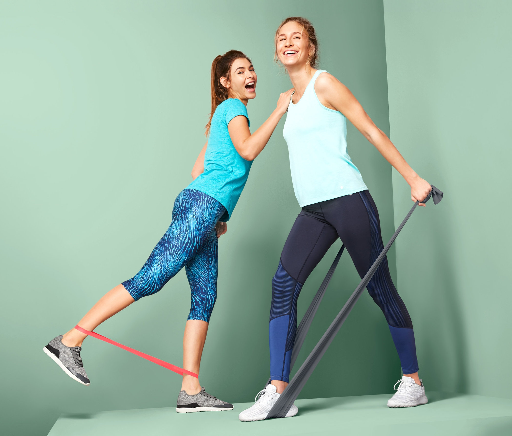 İki kadın 2 fitness bandı ve 2 lastik bant ile egzersiz yapıyor.