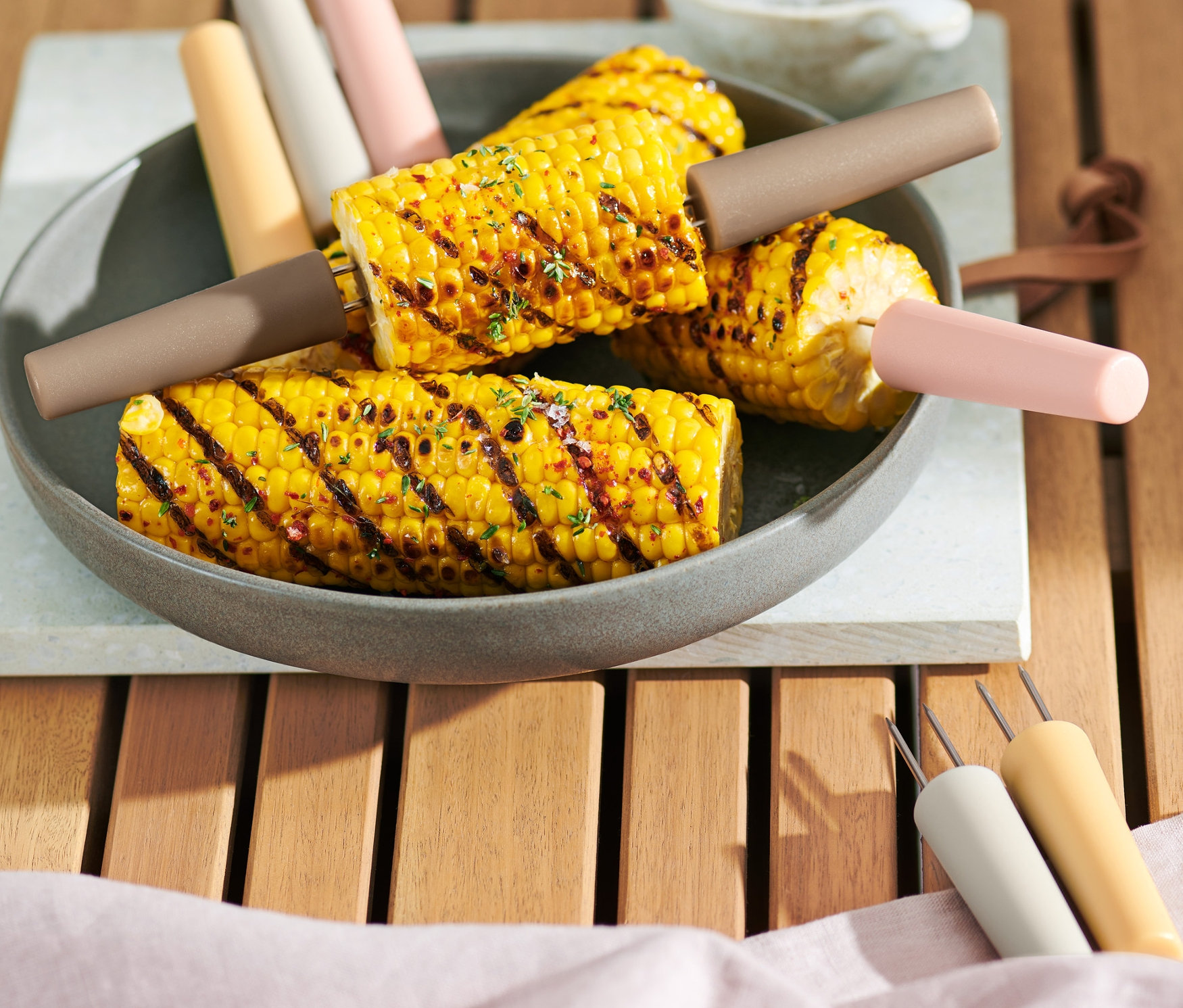 Tabakta 8 adet mısır tutuculu ızgara mısır.