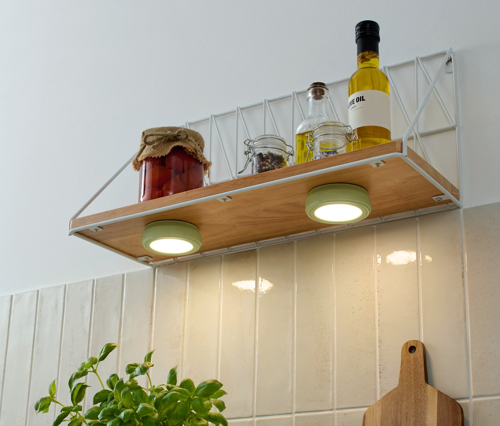 Bir rafta 2 adet Çok Fonksiyonlu LED Lamba, kavanozlar ve yağlar bulunmaktadır.