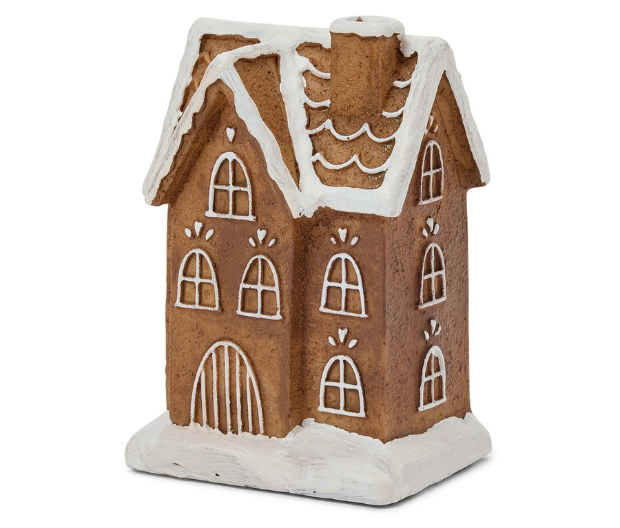 Penceresinde ve çatısında beyaz krema olan kahverengi zencefilli kurabiye evinin yakın çekimi.