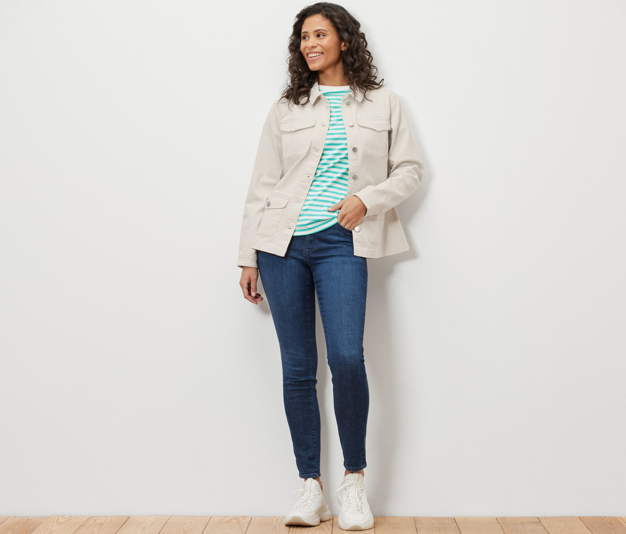 Kadın kargo cepli kot mont, mavi kot pantolon ve beyaz spor ayakkabı giyiyor.