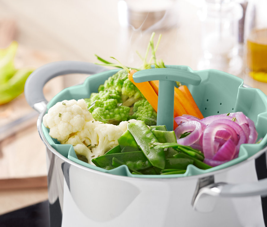 Tencere üzerinde buharlı pişirme aparatında sebzeler.