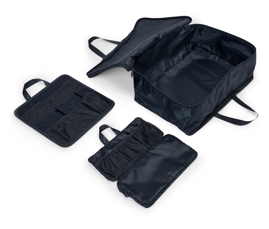 Saplı ve file cepli üç adet lacivert kumaş çanta beyaz bir zeminde duruyor. Bir çanta açık ve içini gösteriyor.