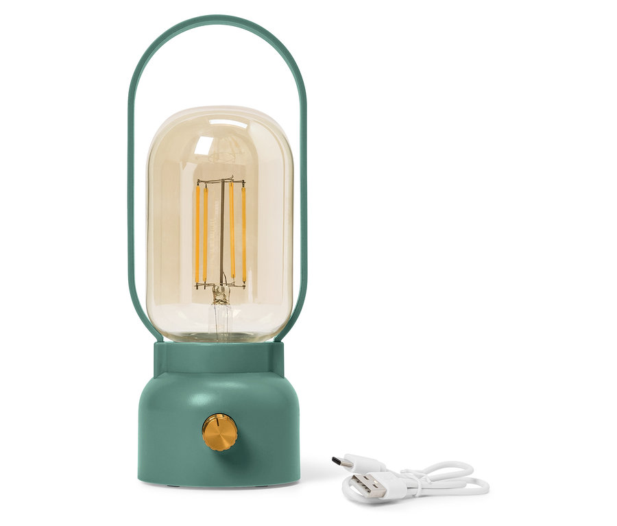 Sarı cam ampullü yeşil bir lamba beyaz bir USB kablosunun yanında duruyor.