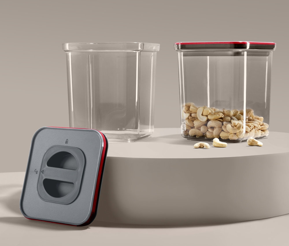 İki adet vakumlu taze saklama kutusu, biri boş, diğeri kaju fıstığı dolu ve bir vakum pompası.