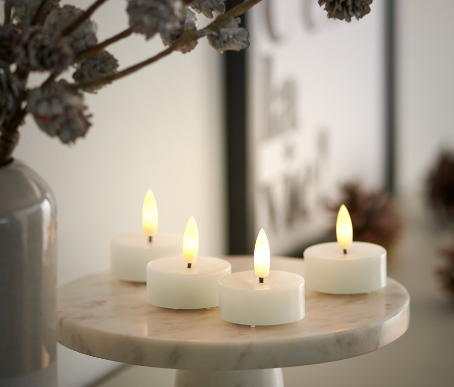 Mermer bir stand üzerinde dört adet kırık beyaz LED gerçek bal mumu tealight.