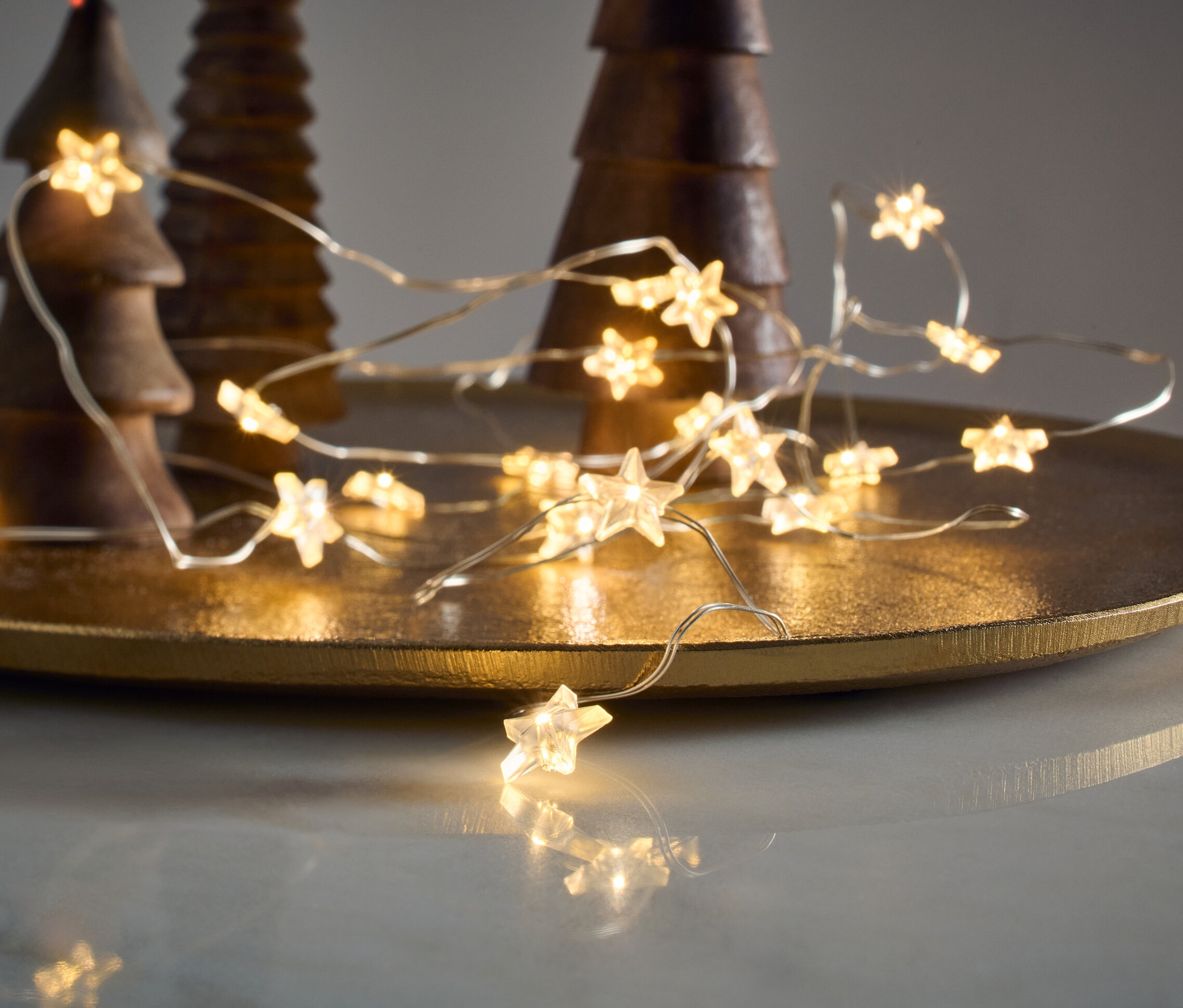 LED Mikro Işık Zinciri, Yıldızlar, ahşap dekoratif ağaçların yanında altın bir tepside duruyor.