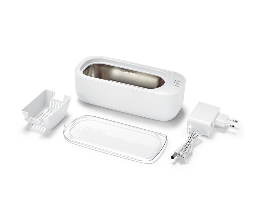 Beyaz bir arka planda ultrasonik temizleyici ve aksesuarları.