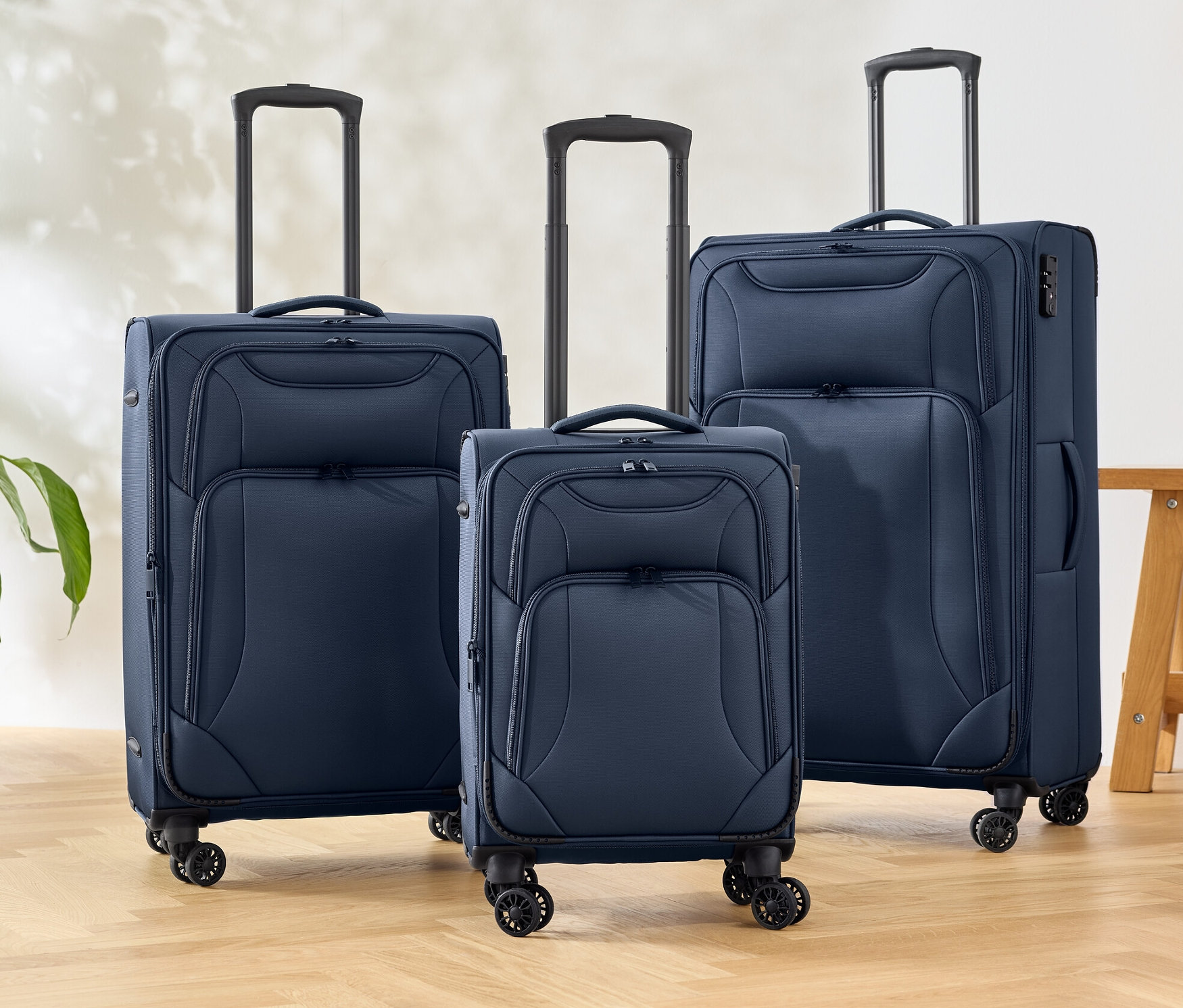 Üç adet mavi tekstil valiz bir zeminde duruyor.