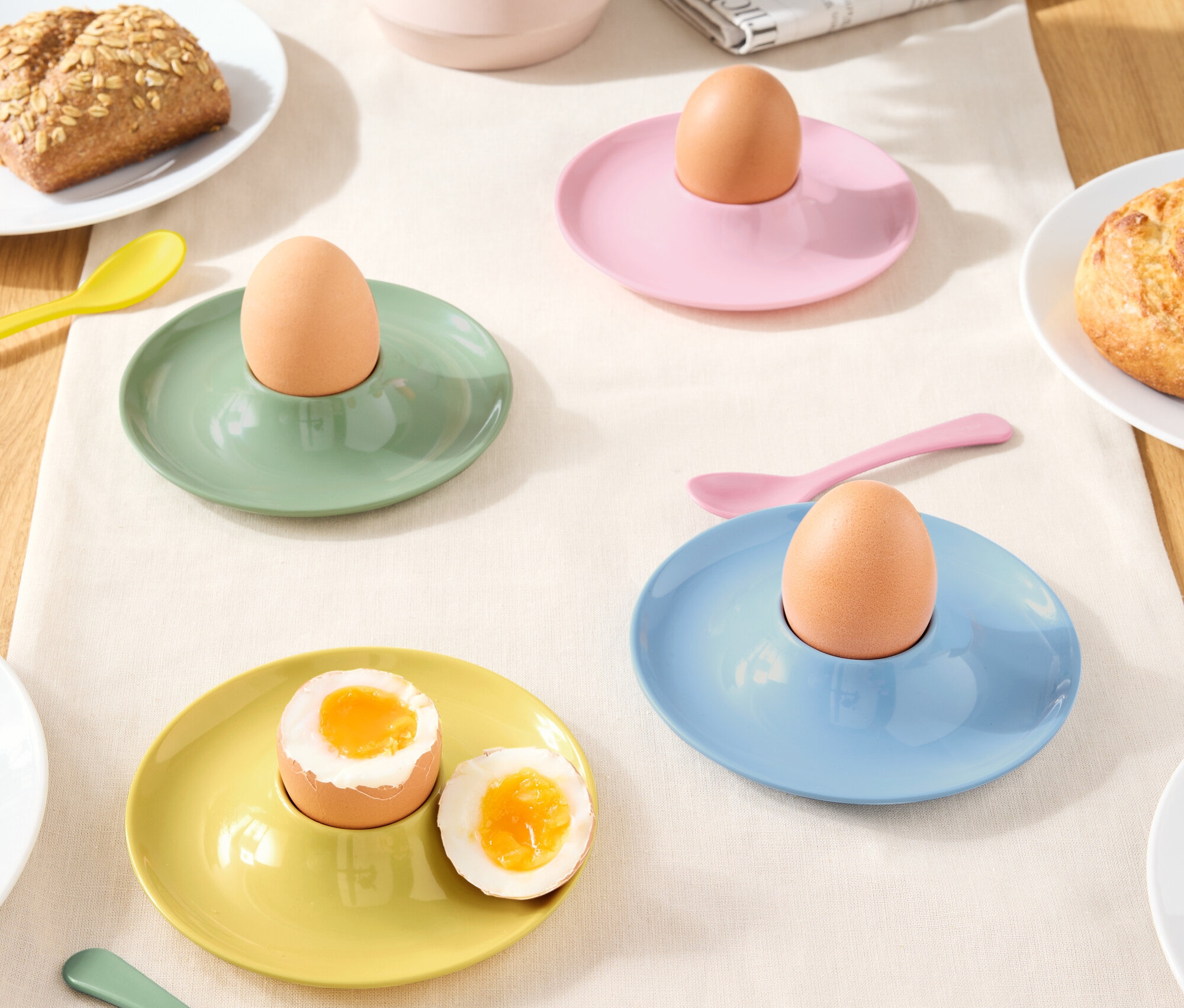 Masa örtüsü üzerinde yumurta ve kaşıklarla birlikte farklı renklerde yumurtalıklar.