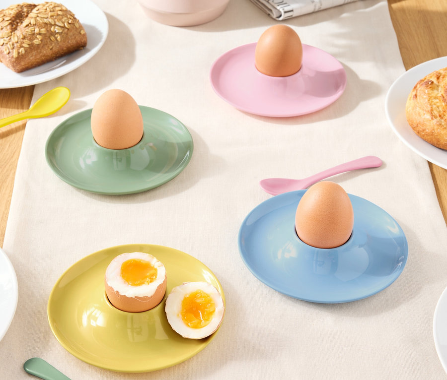 Masa örtüsü üzerinde yumurta ve kaşıklarla birlikte farklı renklerde yumurtalıklar.