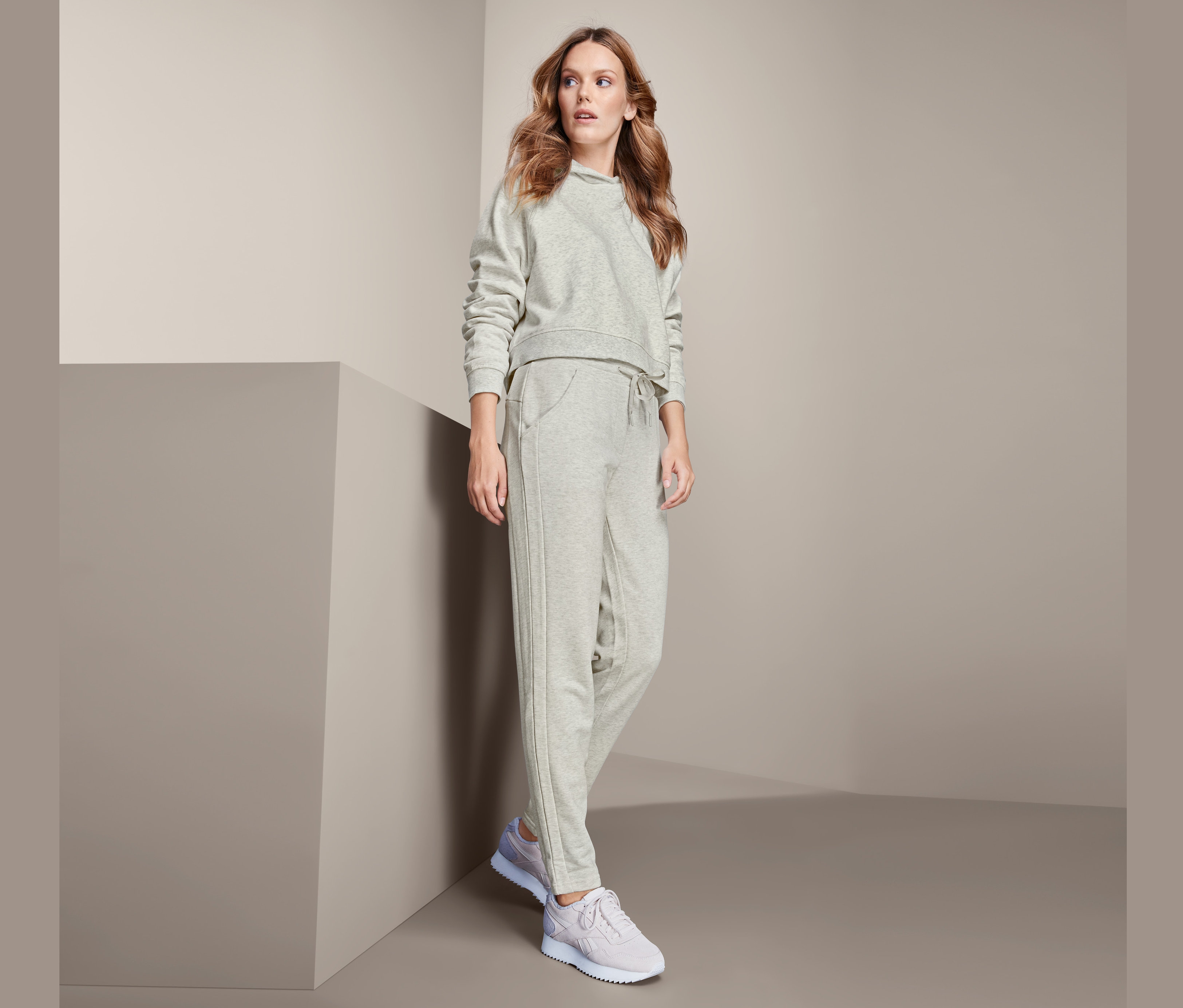 Kadın gri eşofman altı ile poz veriyor.