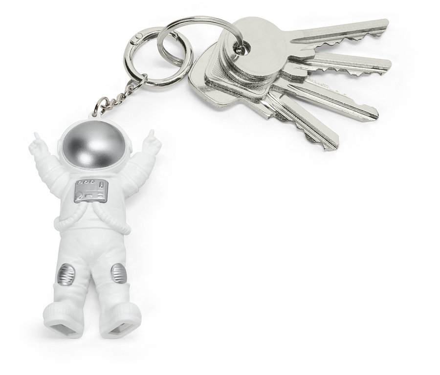 Beyaz kıyafetli ve gümüş kasklı küçük bir astronot figürüne sahip, bir demet gümüş anahtara takılı anahtarlık.