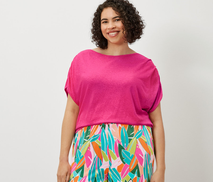 Bir kadın baskılı palazzo pantolon ve keten karışımlı tişört giyiyor.