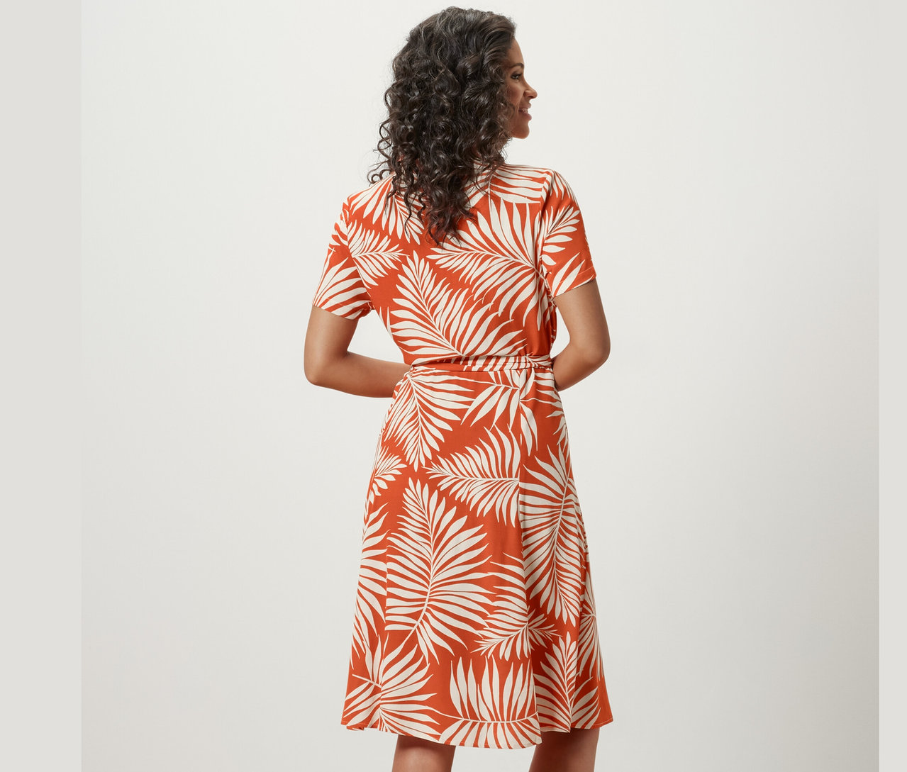 Kadın baskılı gömlek elbiseyle poz veriyor.