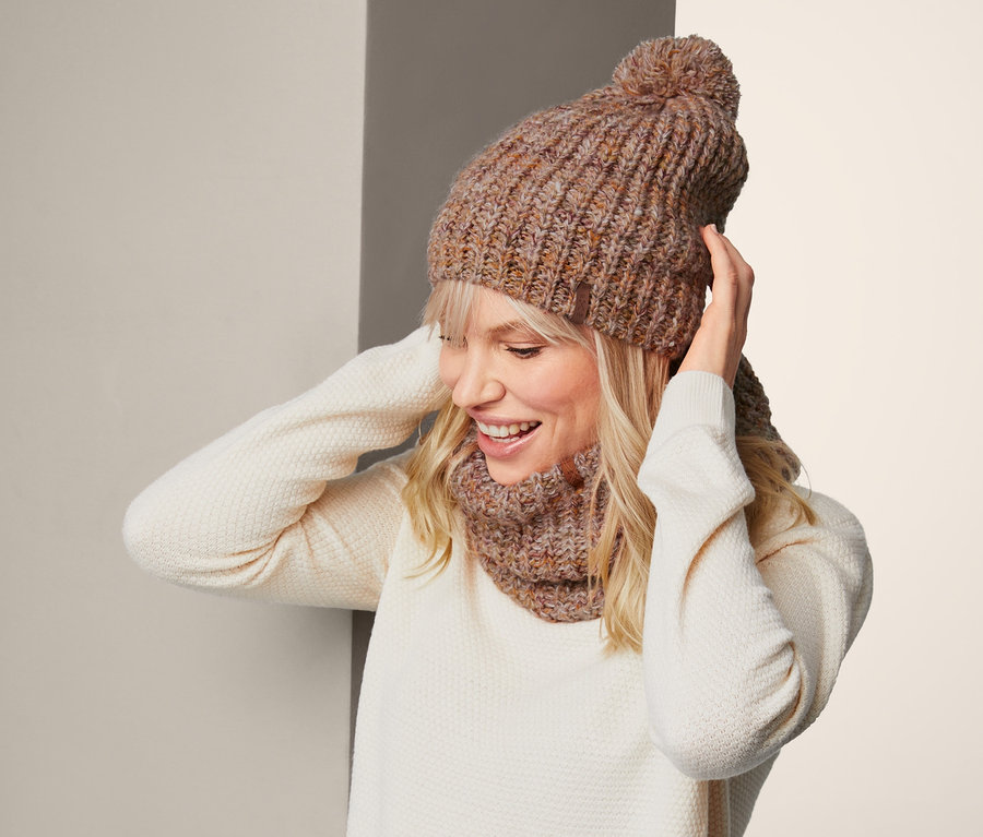 Sarışın kadın örgü beresini düzeltiyor.