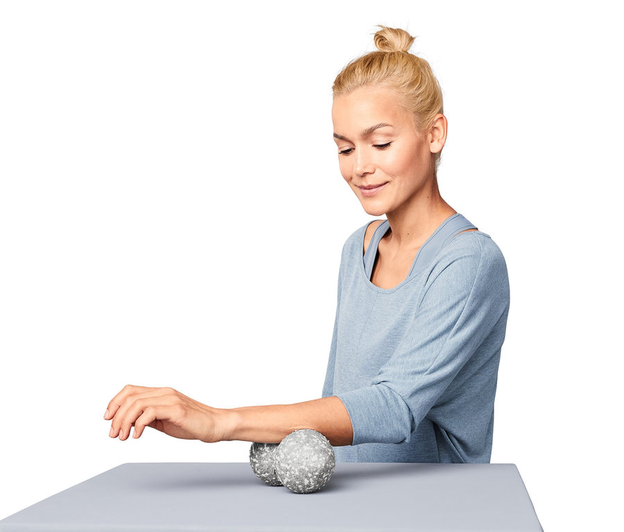 Kadın ön kolunda İkili Bağ Doku Masaj Topu kullanıyor.