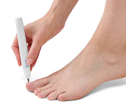 Kadın ayak tırnağında manikür ve pedikür aleti kullanıyor.