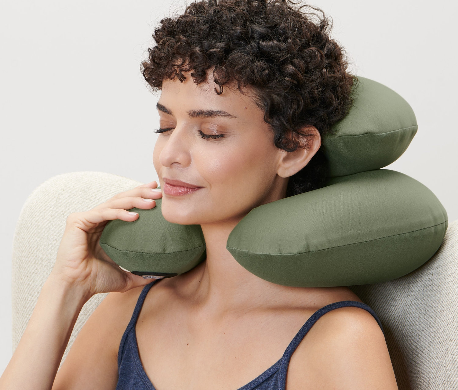 Kadın sandalyede oturuyor ve şişme boyun yastığı kullanıyor.