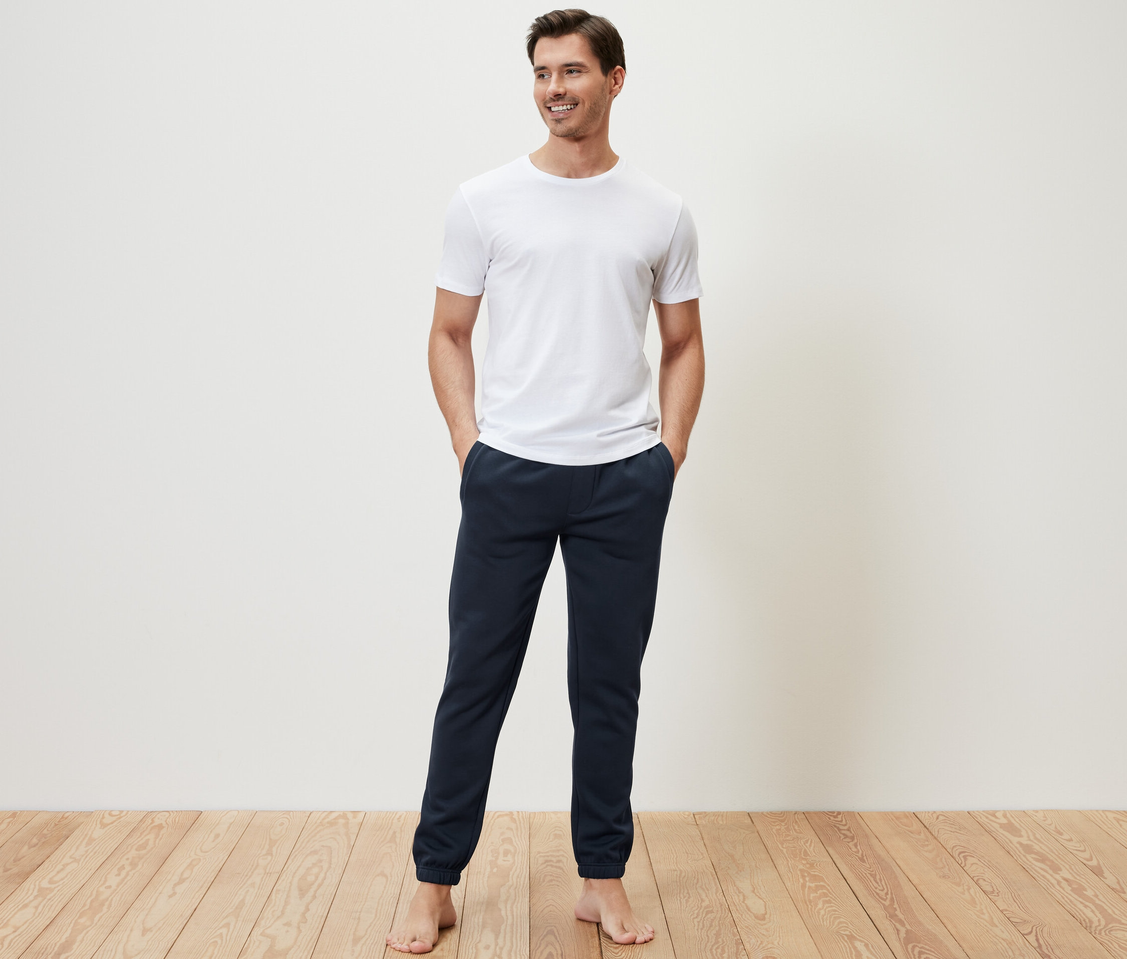 Adam elinde Sweat Pantolon cebinde ayakta duruyor.