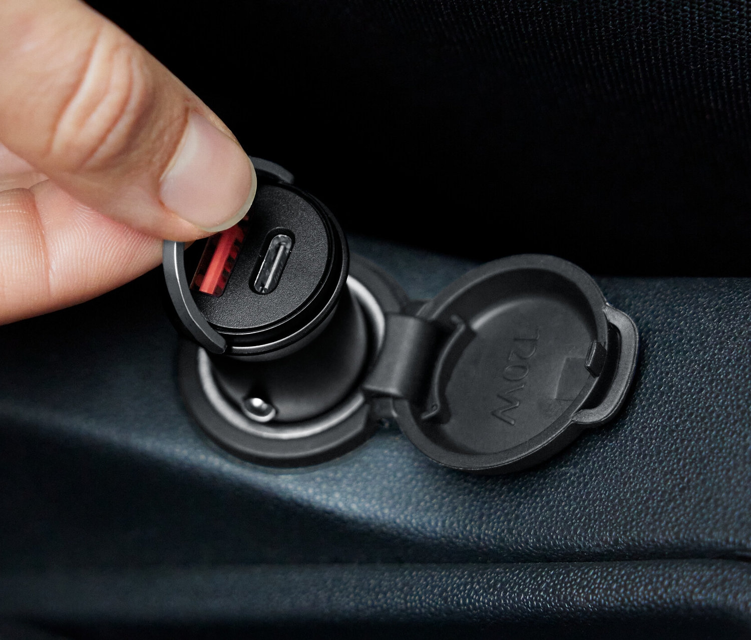 Bir el, Araç Hızlı Şarj Aletini prize takıyor.