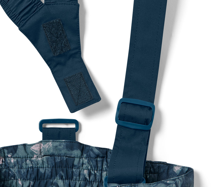 Ayarlanabilir askıları ve tokaları dahil olmak üzere, tamamı baskılı çocuk kayak pantolonunun yakın çekimi.