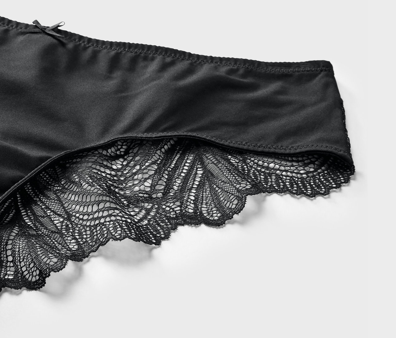 Dantel detaylı siyah Brezilya kesim külotun yakın çekimi.