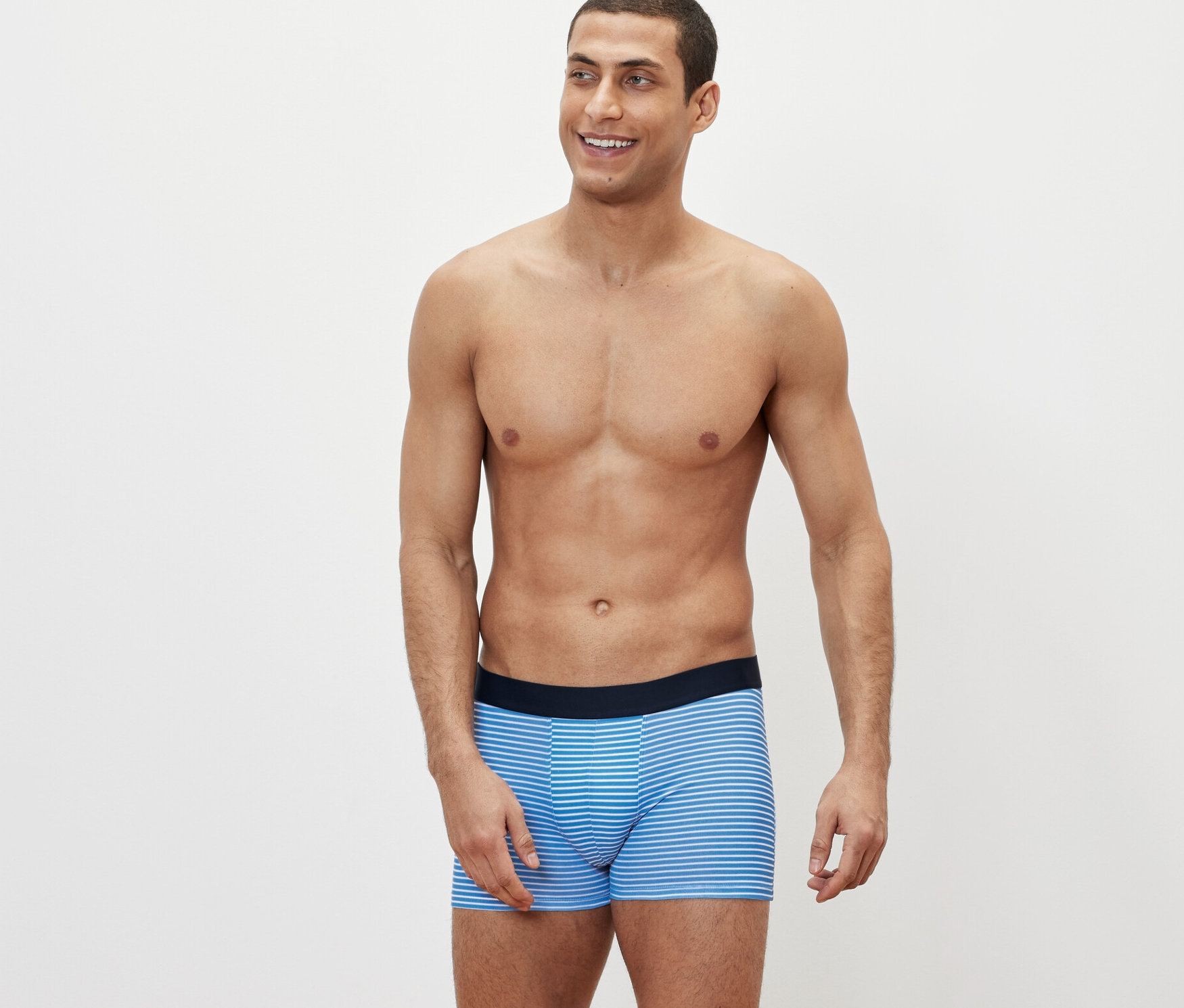 Çizgili 4'lü slip boxer külotlu bir adam poz veriyor.