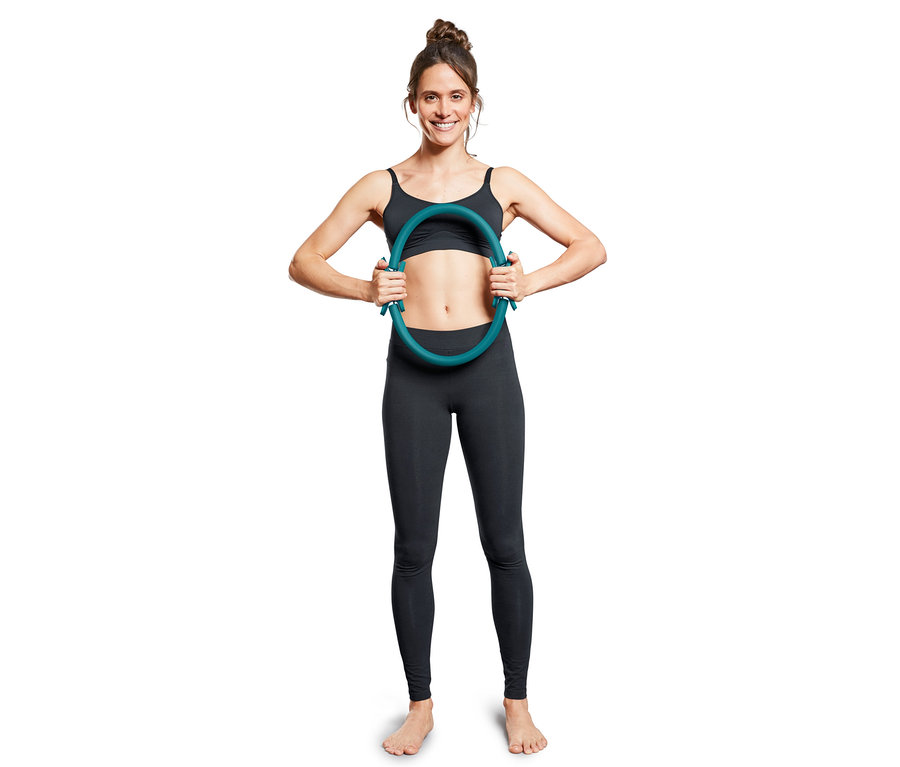 Kadın bir Pilates çemberi tutuyor