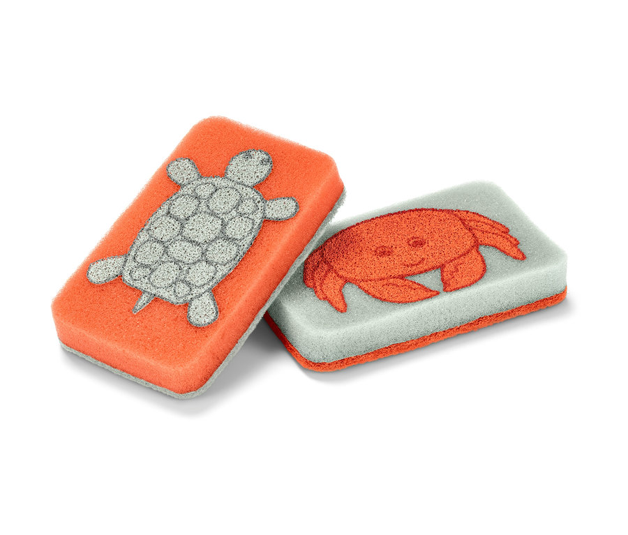 İki adet temizlik süngeri: biri turuncu kaplumbağalı, diğeri gri yengeçli.