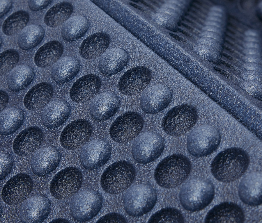 Yuvarlak girintili ve oluklu, mavi katlanabilir izolasyon matının yakın çekimi.