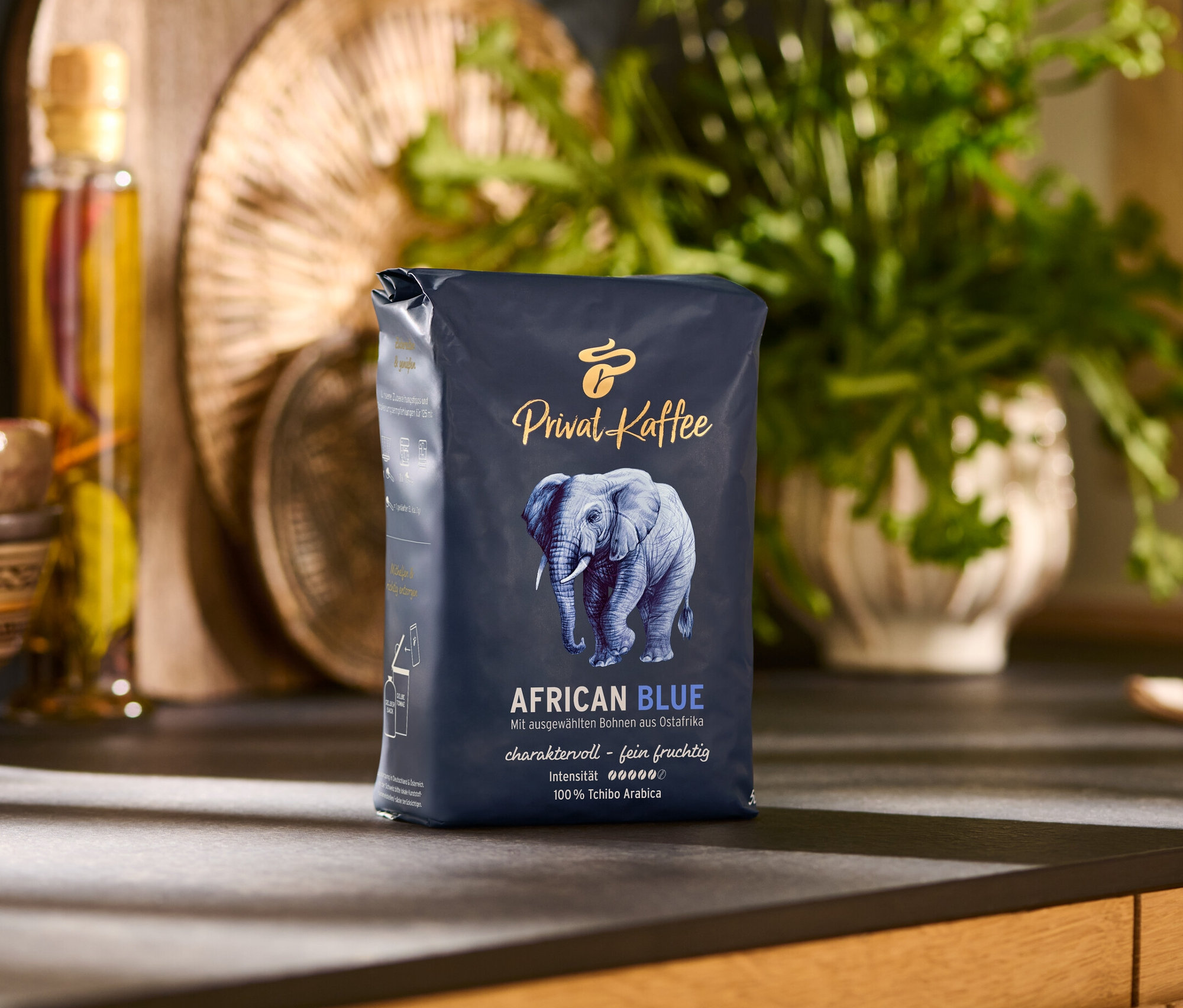 Bir paket Privat Kaffee African Blue - 500 g Çekirdek kahve, mutfak tezgahı üzerinde duruyor.