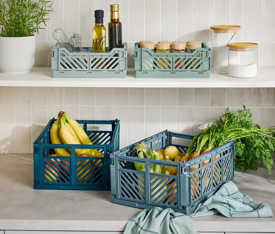 Mutfak tezgahında üç adet katlanabilir saklama kutusu, bir mavi muzlu, bir gri sebzeli ve bir gri mutfak gereçli bulunmaktadır.