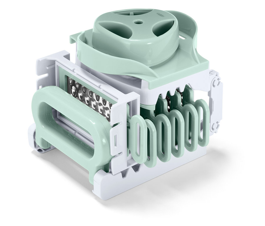 Pastel yeşili ve beyaz renklerdeki bir mutfak sebze doğrayıcısının yakın çekim görüntüsü.