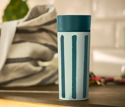 Çizgili Coffee-to-go Kupası bir masanın üzerinde duruyor.