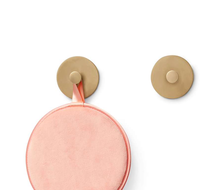 Pembe makyaj süngeri altın rengi bir kancaya asılı, yanında başka bir altın rengi kanca var.