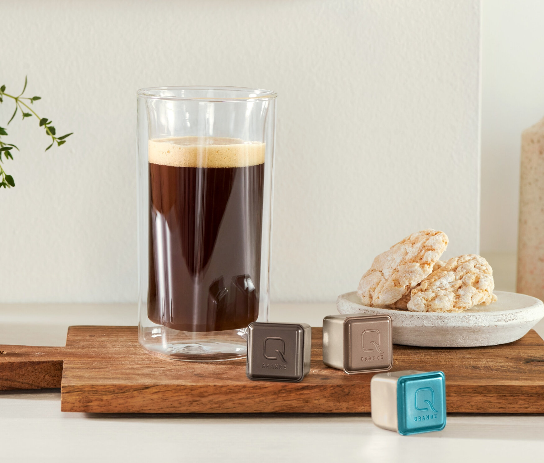 Kurabiye ve üç kapsülün yanında tahta bir tahta üzerinde bir bardakta kahve. 2 Latte Macchiato Bardağı