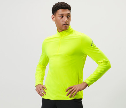 Adam neon sarısı fonksiyonel termal üst ile poz veriyor.