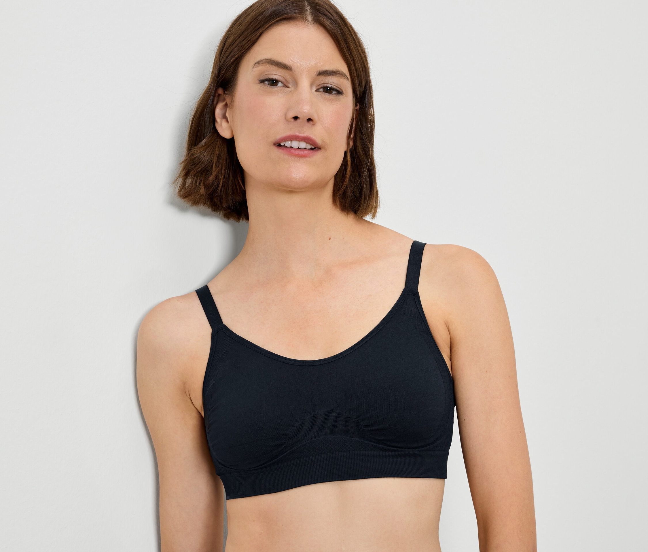Kadın siyah sütyen giyiyor.