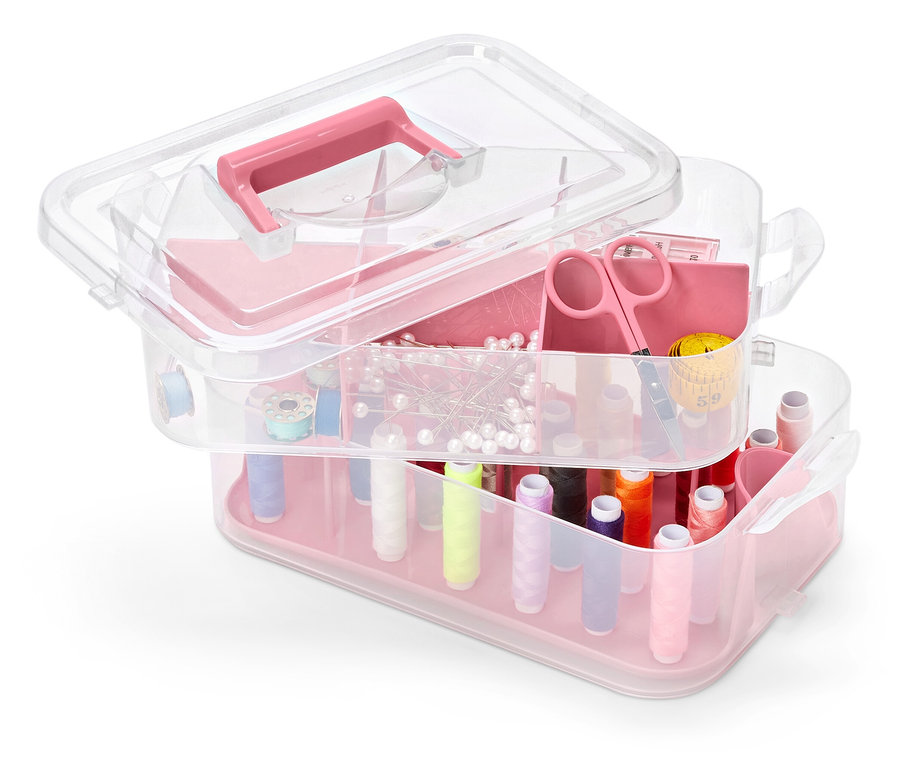 Pembe detaylara sahip, çok katlı, şeffaf plastik alet kutusu, dikiş aksesuarlarıyla dolu.