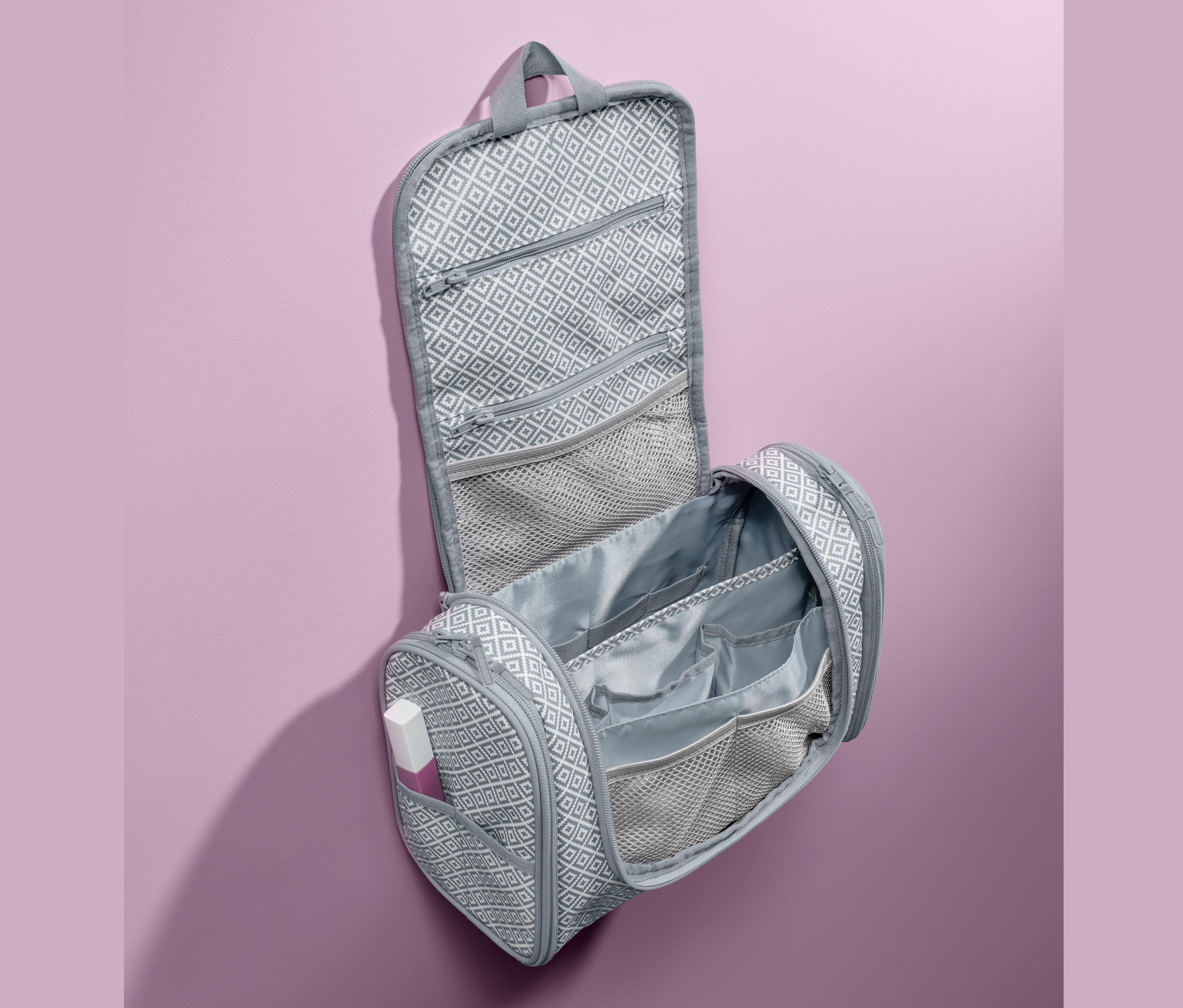 Açık, gri, geometrik desenli askılı bakım çantası.